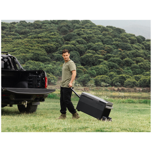 EcoFlow Glacier Portable Refrigerator Electric Cooler with 120W Compressor being used outdoors, curbside next to a truck.