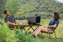 Load image into Gallery viewer, EcoFlow WAVE 2 Portable Air Conditioner on camping table with two people outdoors.
