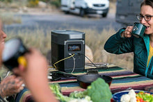 Load image into Gallery viewer, EcoFlow DELTA 1300 Portable Power Station in outdoor use, charging devices on a picnic table.
